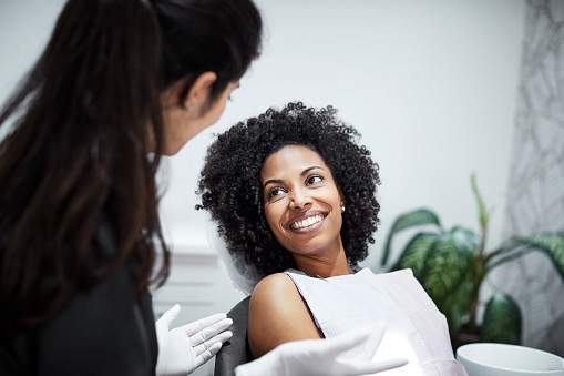 Beautiful Black woman talking to dentist during dental exam and cleaning at San Francisco Dental Arts in San Francisco, CA