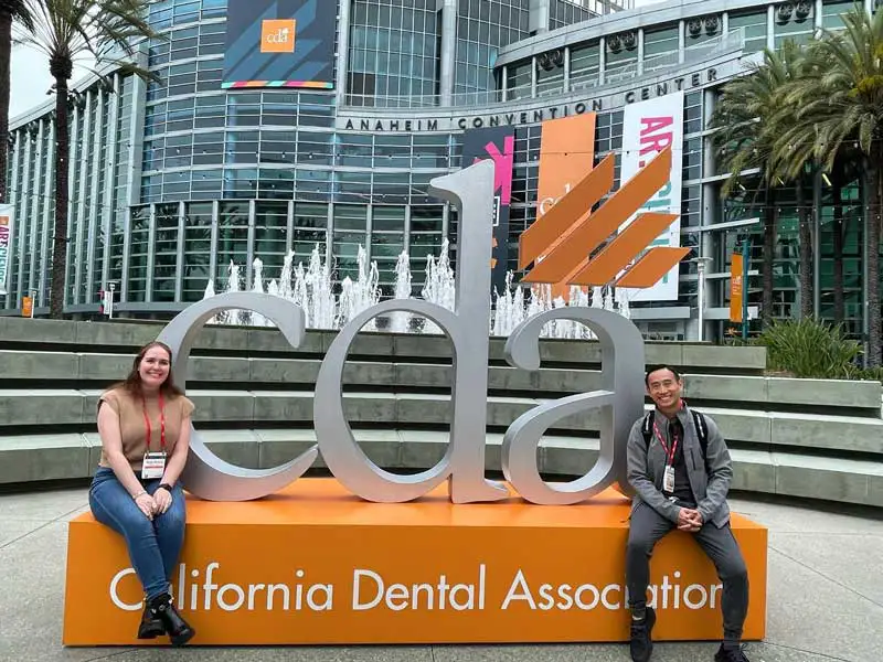 Dr. Stanley smiling at CDA across from another teammate.