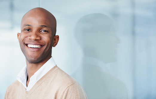 Young black man smiling with veneers with blue background at San Francisco Dental Arts in San Francisco, CA