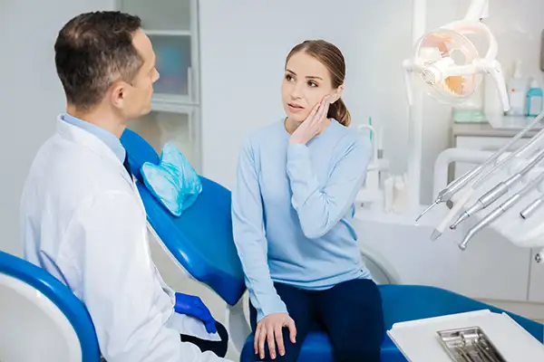 Concerned patient discussing her tooth pain with her dentist while sitting in a dental chair at San Francisco Dental Arts in San Francisco, CA