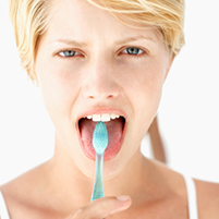 A person brushing their tongue with a toothbrush